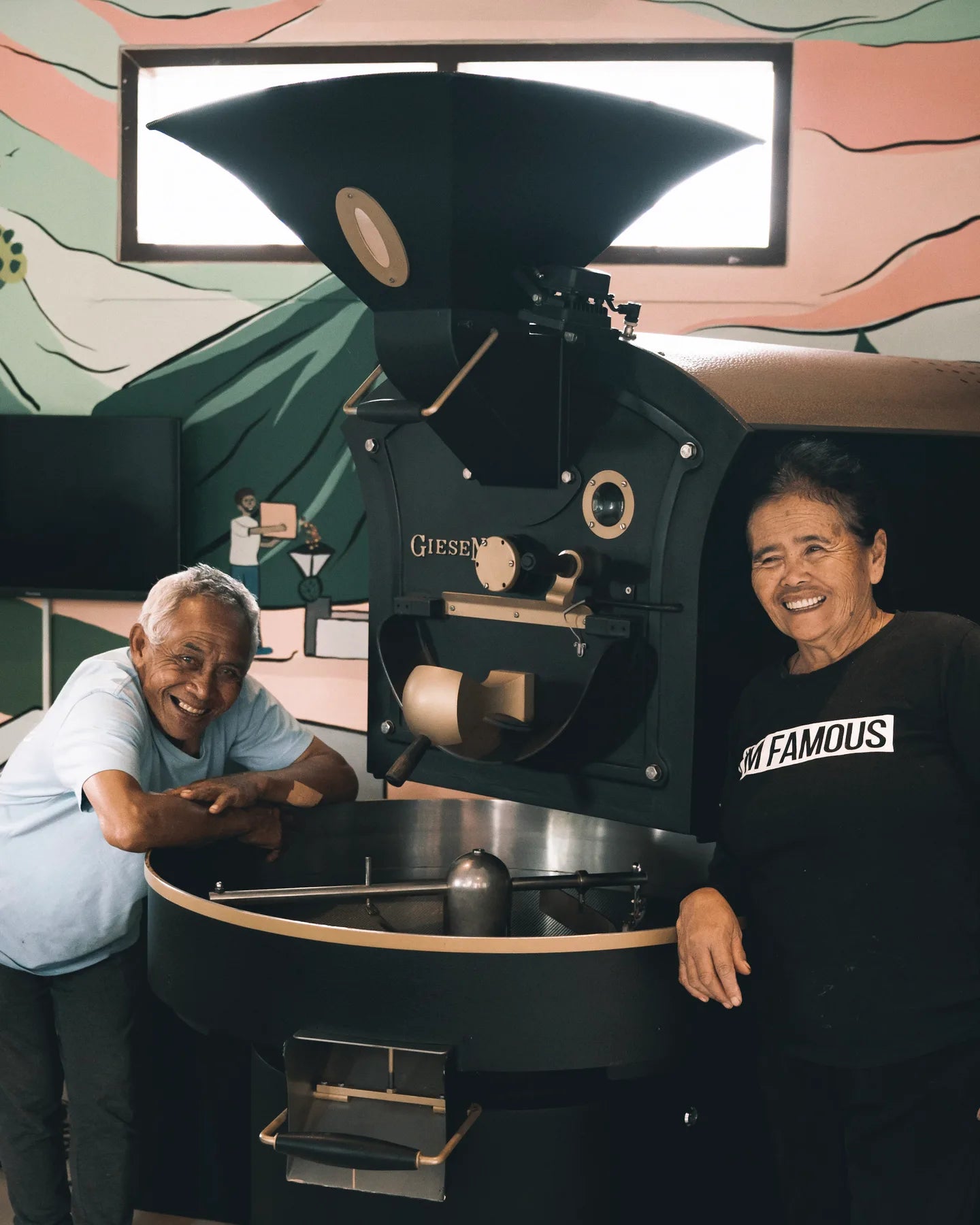 Dua orang di samping mesin penyangrai kopi